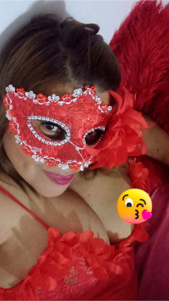 Hermosa dama de compañia con antifaz rojo