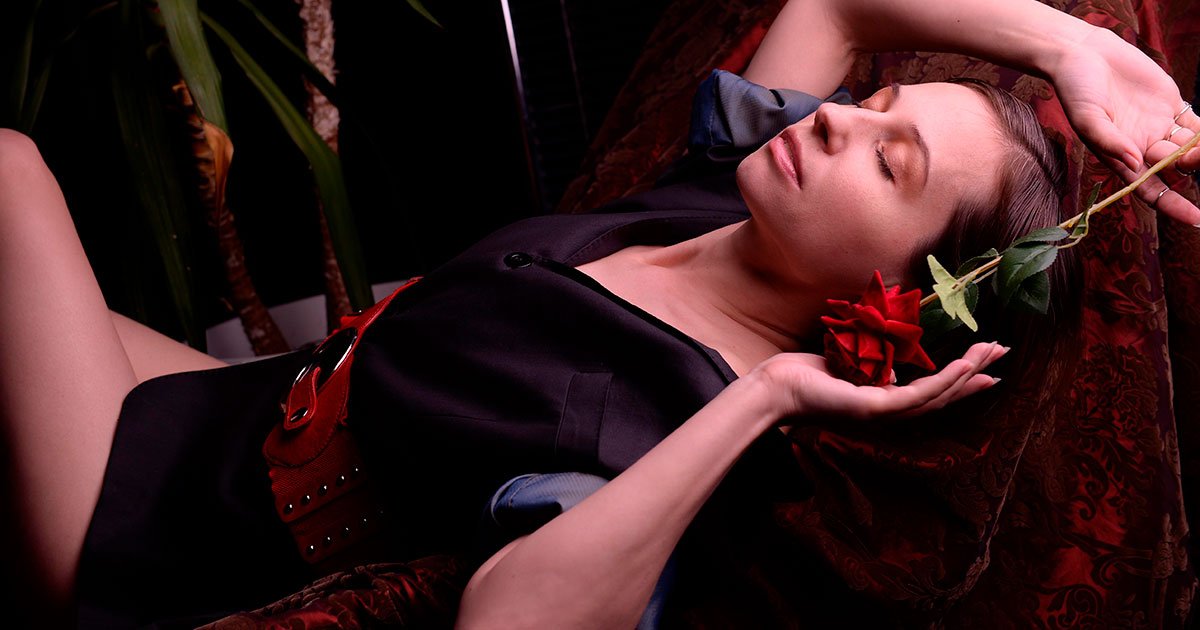 Mujer recostada con una rosa roja